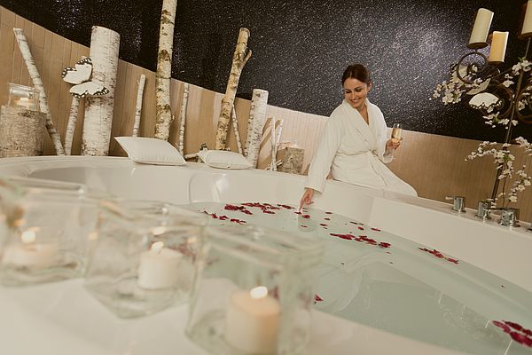 Frau schaut sich unter Kerzenschein das Romantikbad an