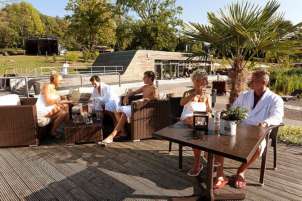 Beisammensitzen mehrerer Personen auf der Außenterrasse des Sauna-Restaurants